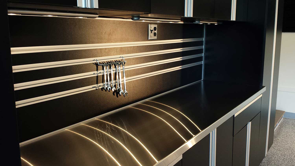 garage-black-cabinets-lighting-steel-countertop